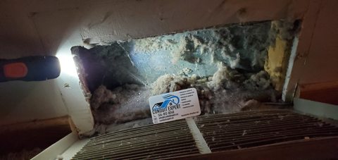 Débris derrière une grille de ventilation